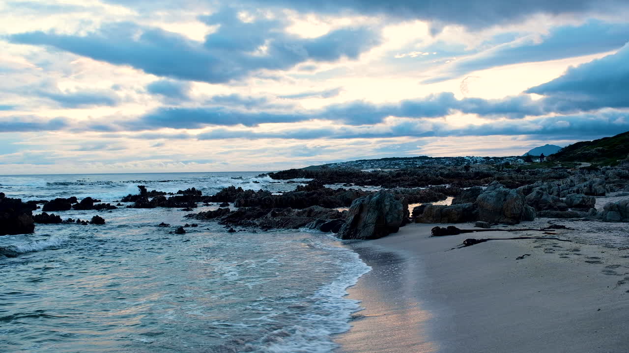 panorámico atardecer vibrante paisaje nublado como olas vueltas en la playa, dolly en