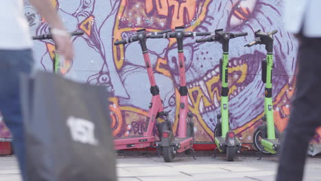 lime scooters parked against a graffiti wall