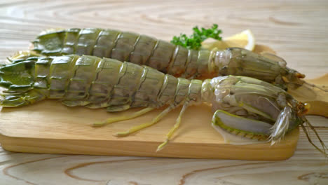 fresh mantis shrimp with lemon on wood board