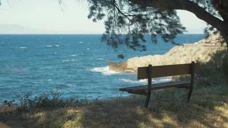 bench sitting empty by rough sea of lesvos island greece