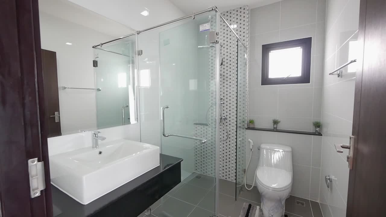 baño moderno y elegante en blanco y negro con cabina de ducha.