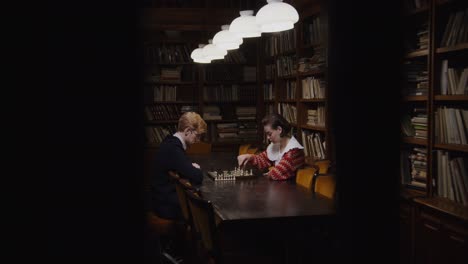 couple playing chess in a vintage library