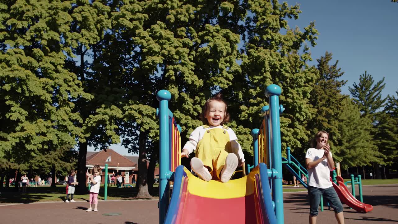 Toddler having fun on a playground slide