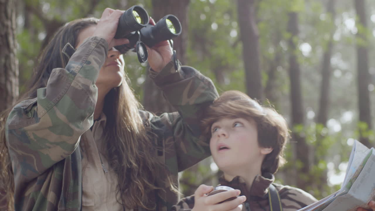 자연 공원에서 야생 동물과 조류 관찰을 탐험하는 백인 어머니와 아들