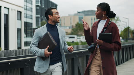 two business people talking on a bridge in the city