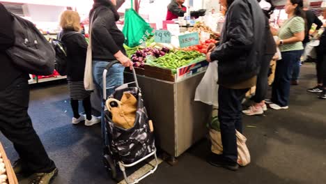 people browsing vegetables at market stalls