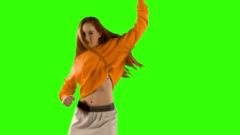 young woman dancing against green screen background