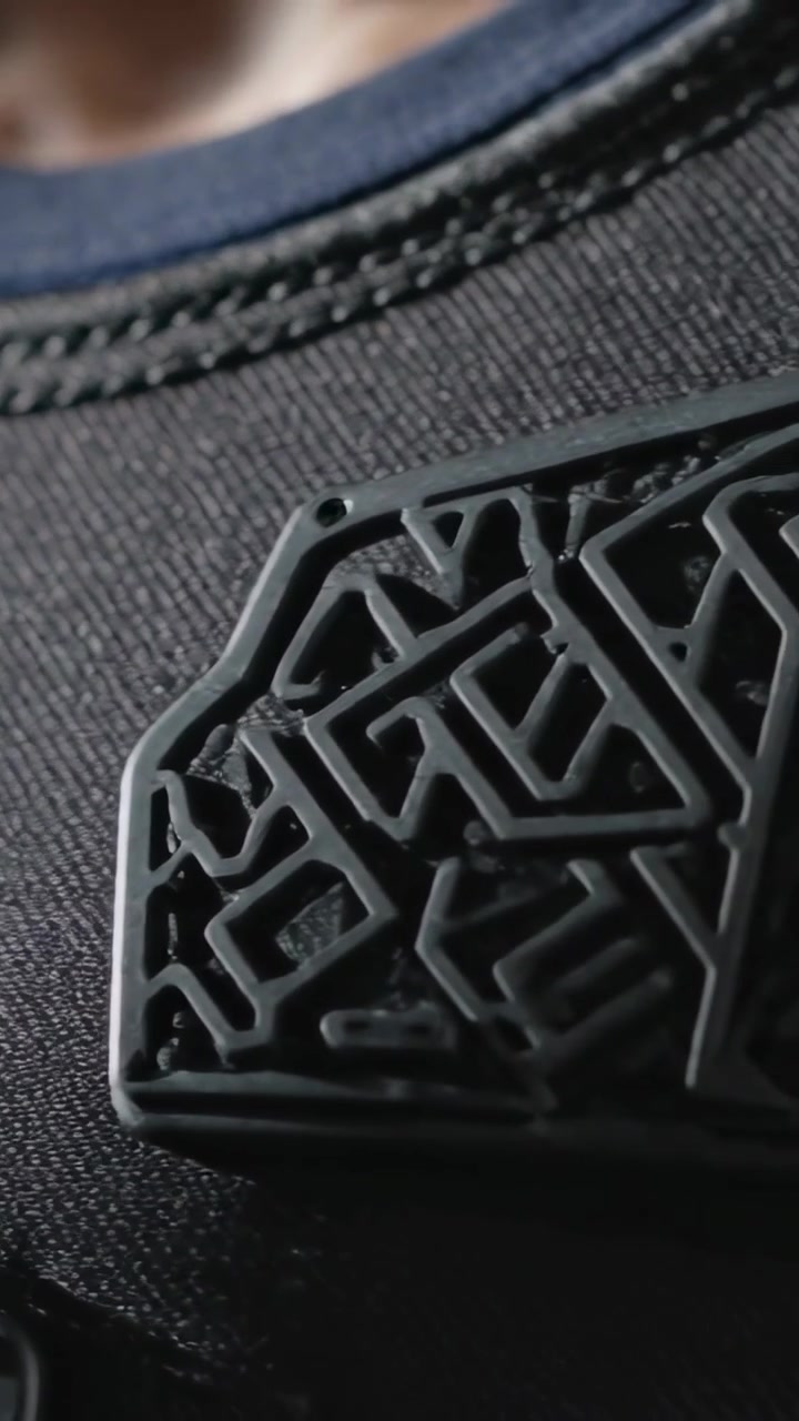 Vertical video: Panning camera across male chest in closeup, highlighting polymer patches and knit