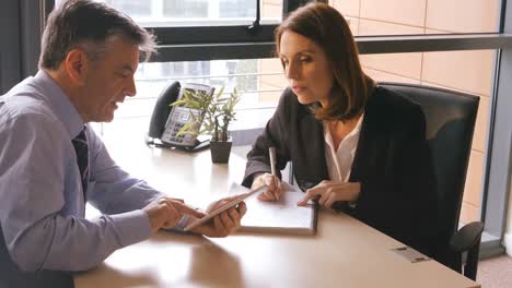 Business-people-discussing-over-digital-tablet