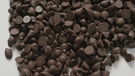 video of close up of multiple chocolate chip over white background