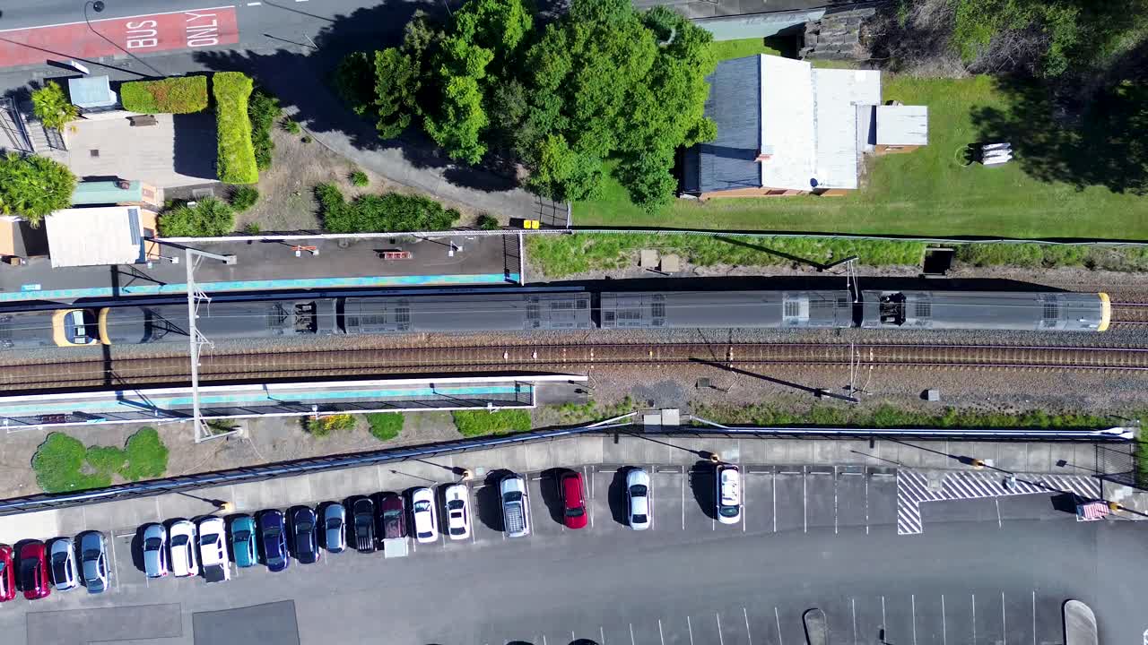 헤리티지 철도역에서 출발하는 열차의 풍경, 통근자 주차장에 주차된 자동차로 둘러싸인 철도 노선