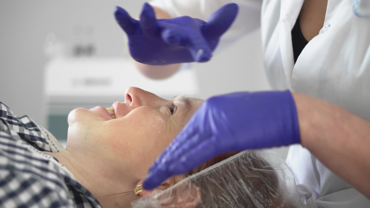 Hardware procedure in cosmetology. Cosmetologist smoothes wrinkles with microcurrent. Peeling, phonophoresis, massage and facelift in a beauty clinic.