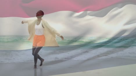 animación de la bandera de los países bajos ondeando sobre una feliz mujer afroamericana corriendo por el agua