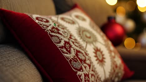 a red pillow with christmas decorations on a couch