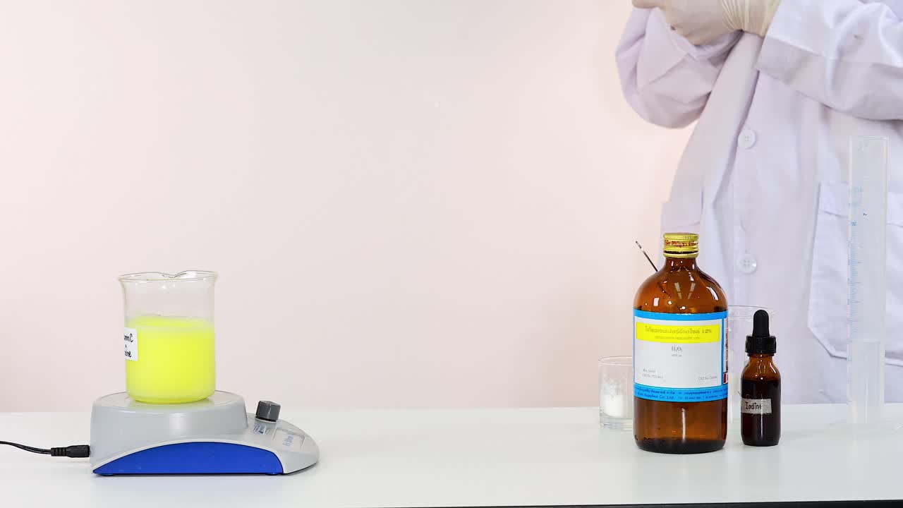 과학자는 실험실 환경에서 요오드 시계 화학 반응 실험을 시연합니다.