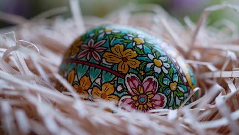 delicado, huevo de pascua pintado a mano que muestra un intrincado diseño floral, suavemente anidado en un fondo suave y tejido de rafia, que muestra la artesanía estacional y la tradición festiva
