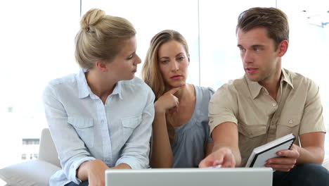 colleagues having a meeting on couch with laptop