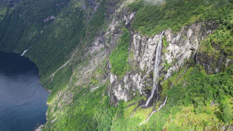 waterfall in geirangerfjord, norway - cinematic nature landscape - aerial circling