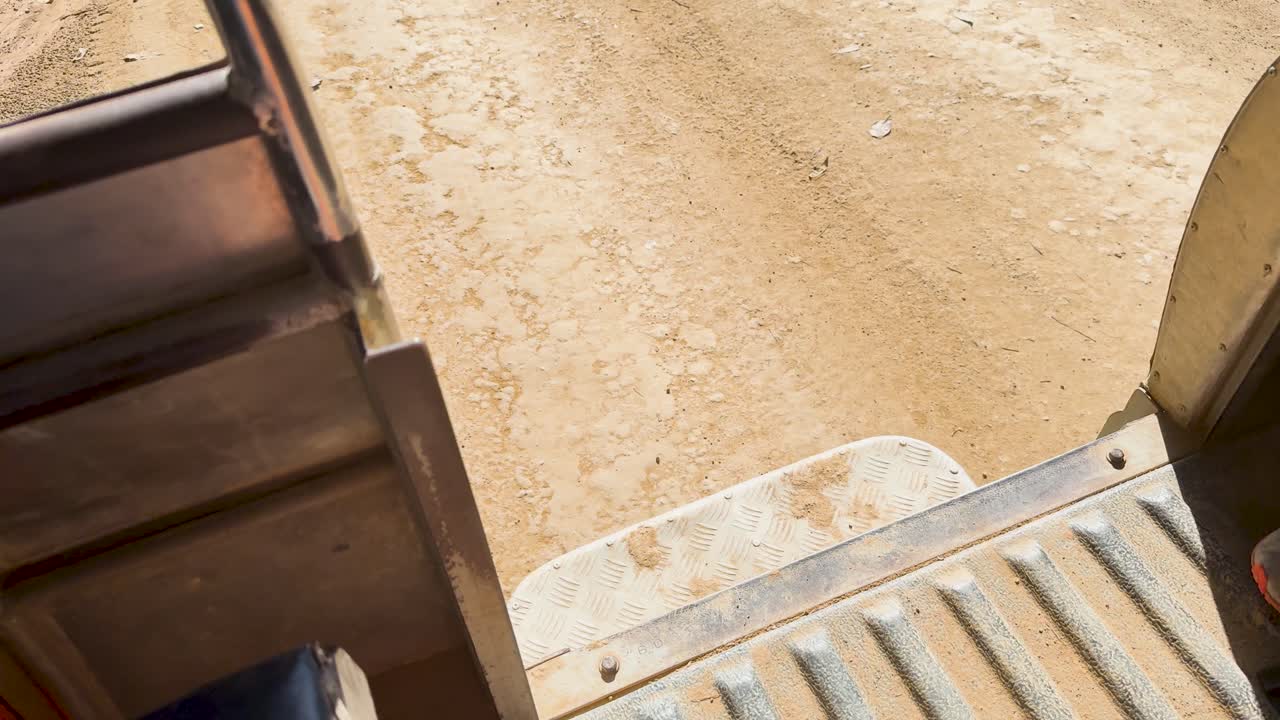 Pickup truck travels along a dusty dirt road
