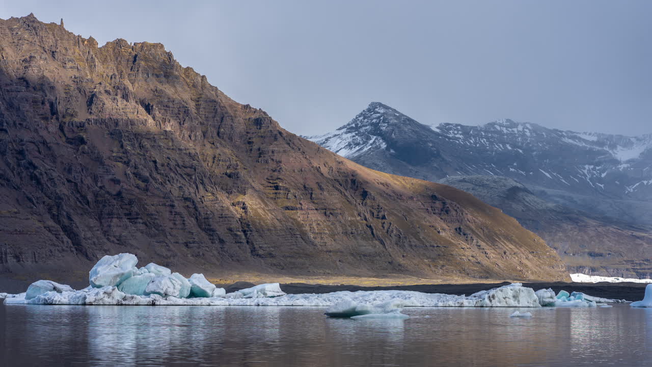 Timelapse of Clouds Shadows on Icebergs in Glacial Lake and Volcanic Hills in Iceland, Skaftafell Glacier