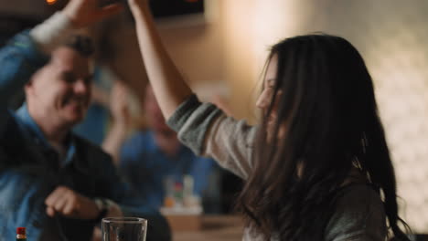 Friends-watching-TV-drinking-beer-and-supporting-team-at-bar.-Medium-shot-of-excited-men-and-women-spending-time-together-cheering-for-team-gesticulating-and-talking.-Entertainment-concept