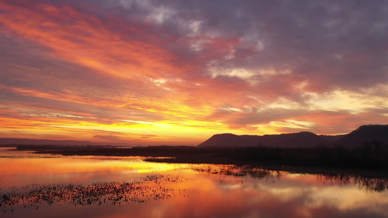 amanecer o atardecer sobre un río con pantano y nubes