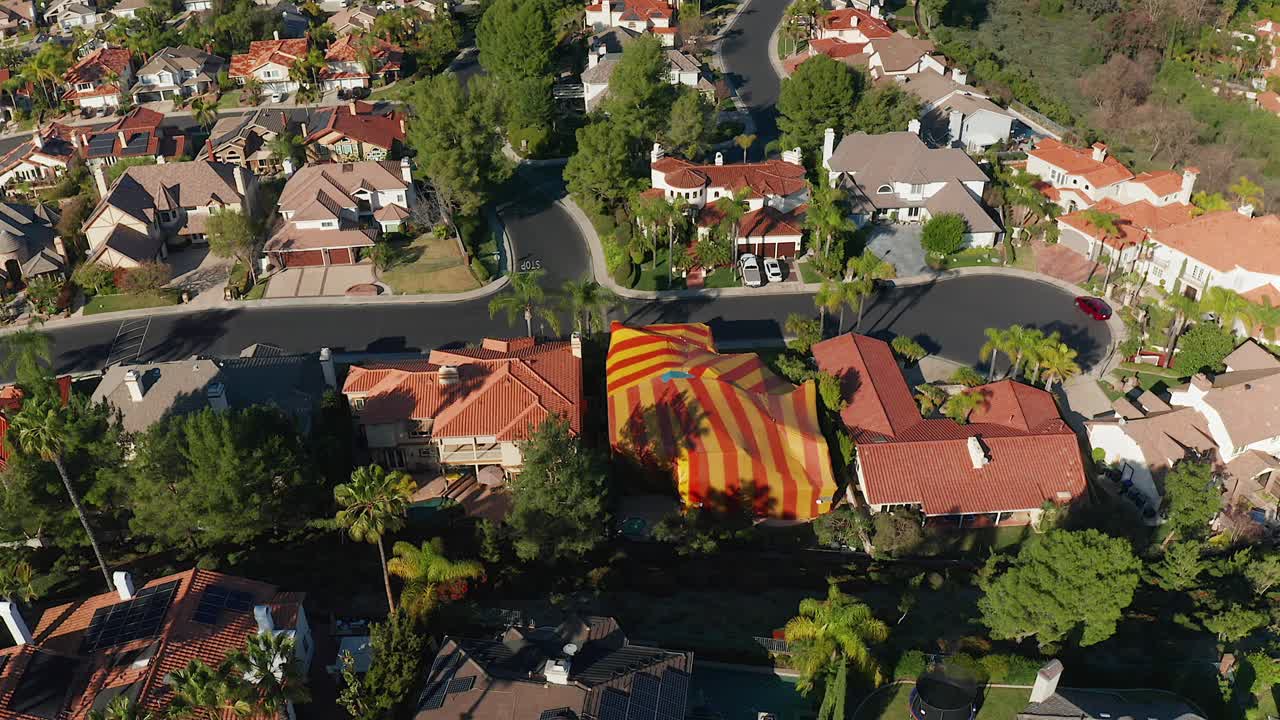 imágenes aéreas giratorias de una casa que ha sido cubierta para termitas
