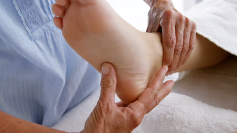 primer plano de una terapeuta masajeando los pies de su paciente