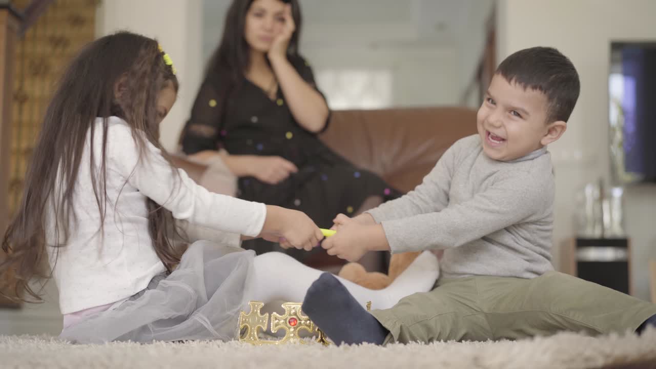 앞면에 장난감을 위해 싸우는 중동의 두 어린 아이와 배경에 절망적으로 머리를 들고 있는 그들의 어머니