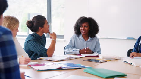 Tutor-De-Secundaria-Femenino-Sentado-En-El-Escritorio-Enseñando-Clase