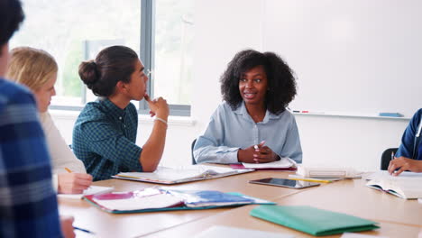 tutora de secundaria sentada en el escritorio de la clase de enseñanza
