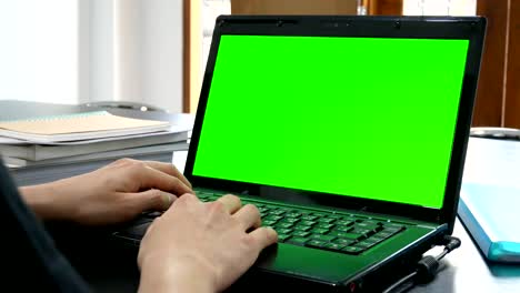 business man hand using laptop computer with green screen for chroma key in office