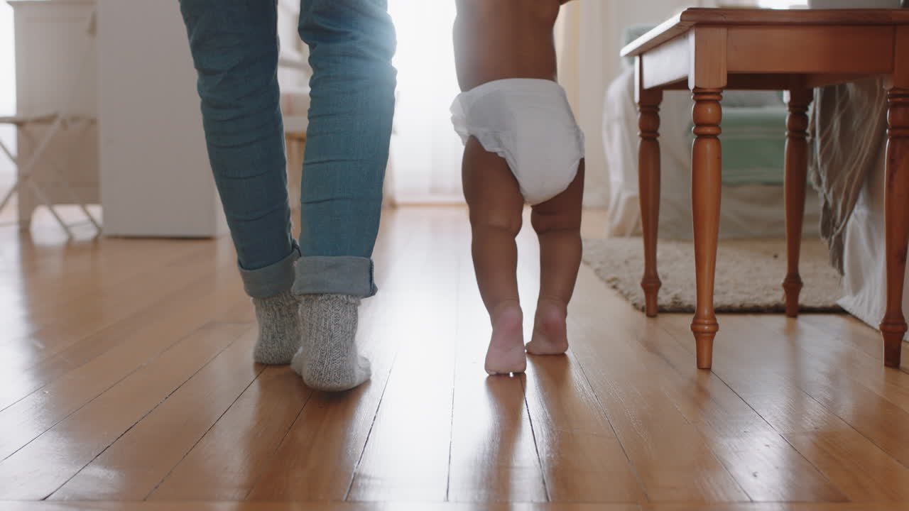 cerca de los pies bebé aprendiendo a caminar niño pequeño dando sus primeros pasos con el padre ayudando al bebé enseñando al niño en casa
