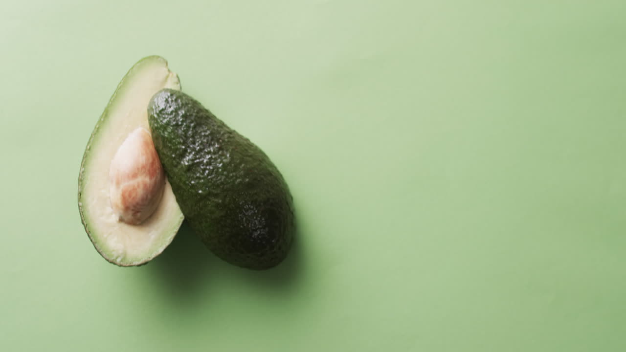 Video di avocado affettato con spazio per il testo su sfondo verde