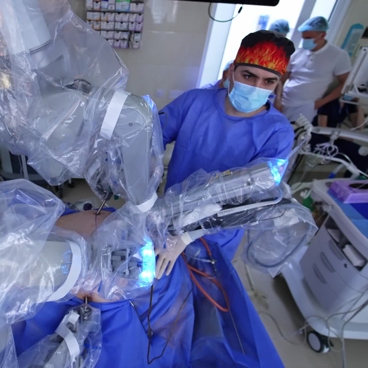 Attentive surgeon follows the operation on the monitor. Robotic equipment carrying out operation. High angle view