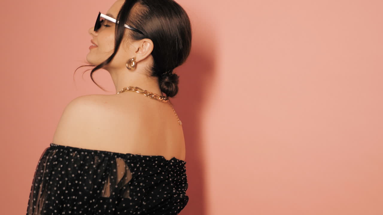 검은색 폴카 도트 드레스 를 입은 세련 된 여자