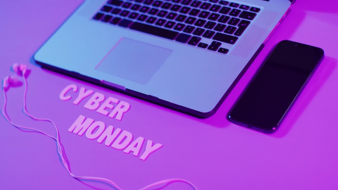 composición de portátil, auriculares y teléfono inteligente con texto de cyber monday en fondo púrpura