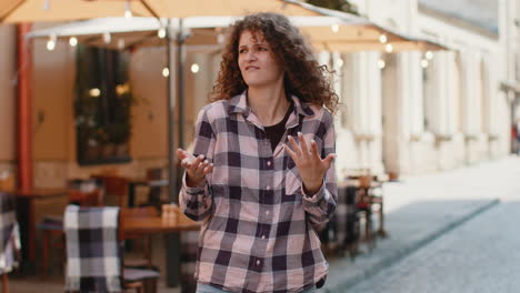 surprised frustrated young woman raising hands asking reason of failure demonstrating disbelief