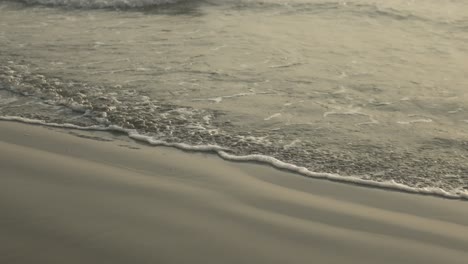 Gentle-waves-lap-at-the-shore-on-a-tranquil-beach-at-sunset