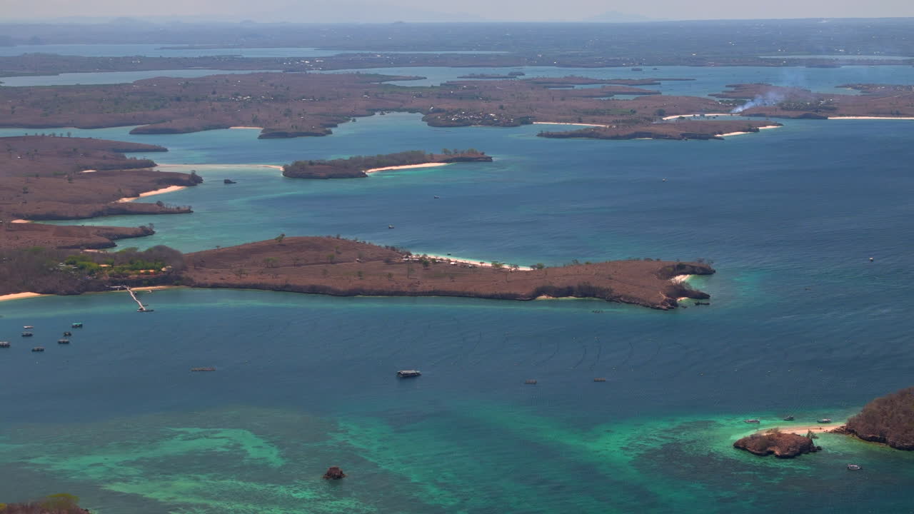 Vista aerea di un arcipelago di isole tropicali con lagune turchesi, barriere coralline poco profonde e litorali. Paesaggio costiero che mostra lagune, scogliere e acque aperte. Paesaggio marino tropicale.