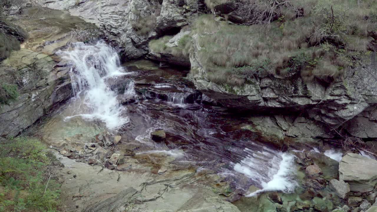 un lecho rocoso de un arroyo sobre el cual el agua fluye cuesta abajo en el parque natural del valle de antrona en la provincia de verbano-cusio-ossola en piamonte, italia