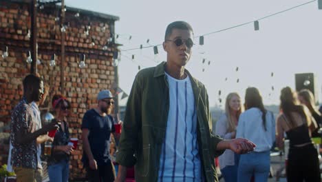 Young-Stylish-Guy-In-Black-Sunglasses-Dancing-Cheerfully-In-Front-Of-The-Camera-At-The-Rooftop-Party-At-Daytime-1