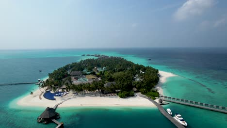 aerial view of maldives resort with beach pool and overwater bungalows