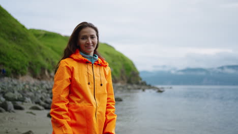 woman in orange rain jacket at the beach