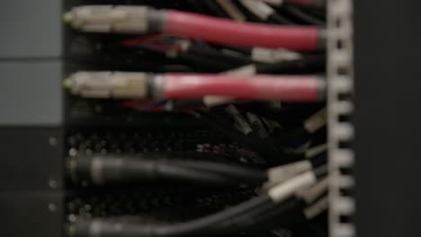 rack focus of server room cables plugged into large data center