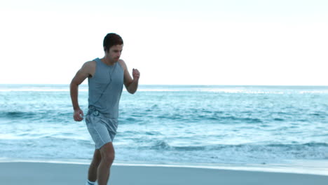 sporty couple running on the beach