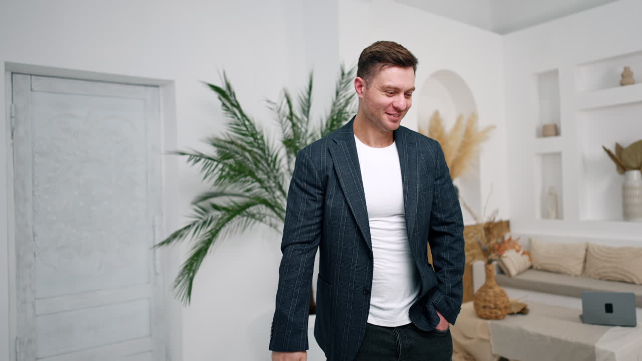 Positive Caucasian male finishes video phone call. Man smiles and looks at camera. Close up.