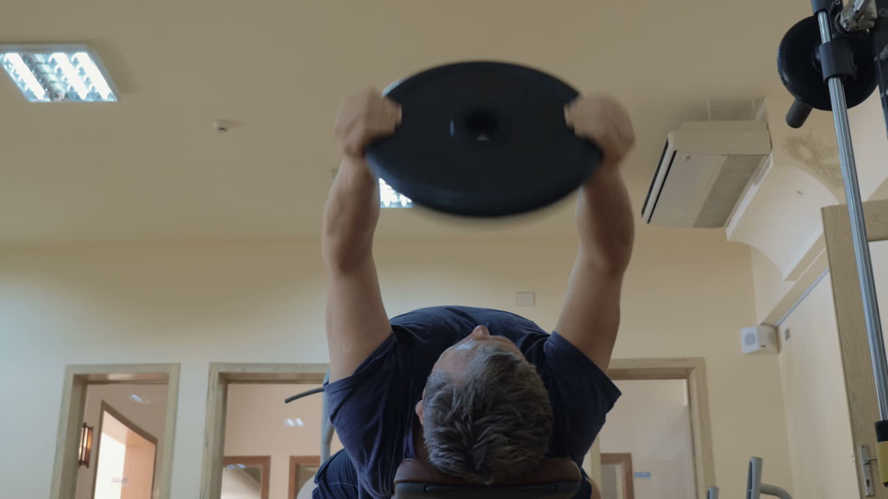 ejercicio con placa de levantamiento de pesas acostada en el banco