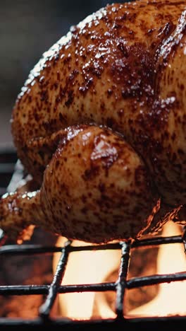 close-up video of a roasted chicken on a grill, showcasing a juicy, crispy texture with flames