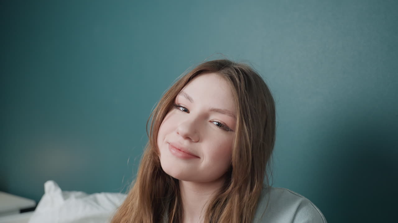 Vibrant cheerful portrait. Closeup of happy woman showing silly gestures. Portrait of youthful woman displaying humorous expressions against teal background with natural face makeup